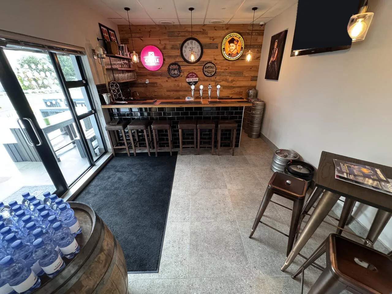 Pub-style bar with beer taps, bar stools and high tables