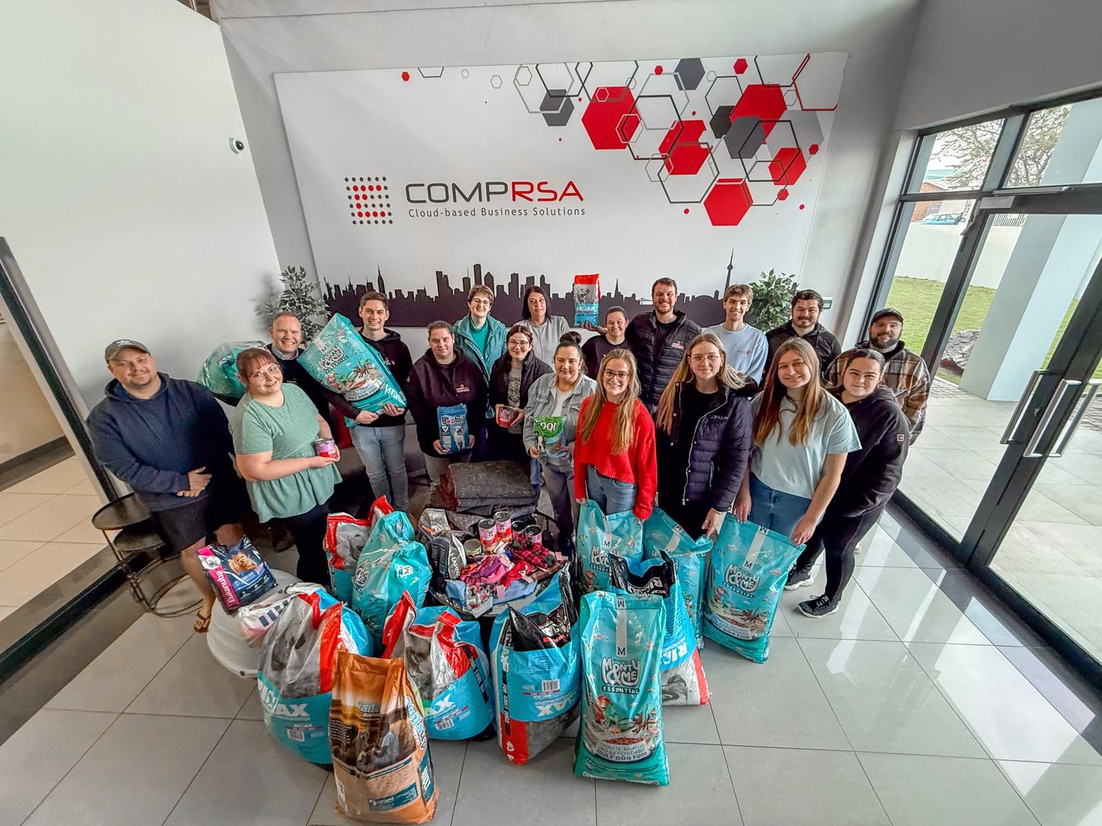 COMPRSA team with pet food donations for local shelters