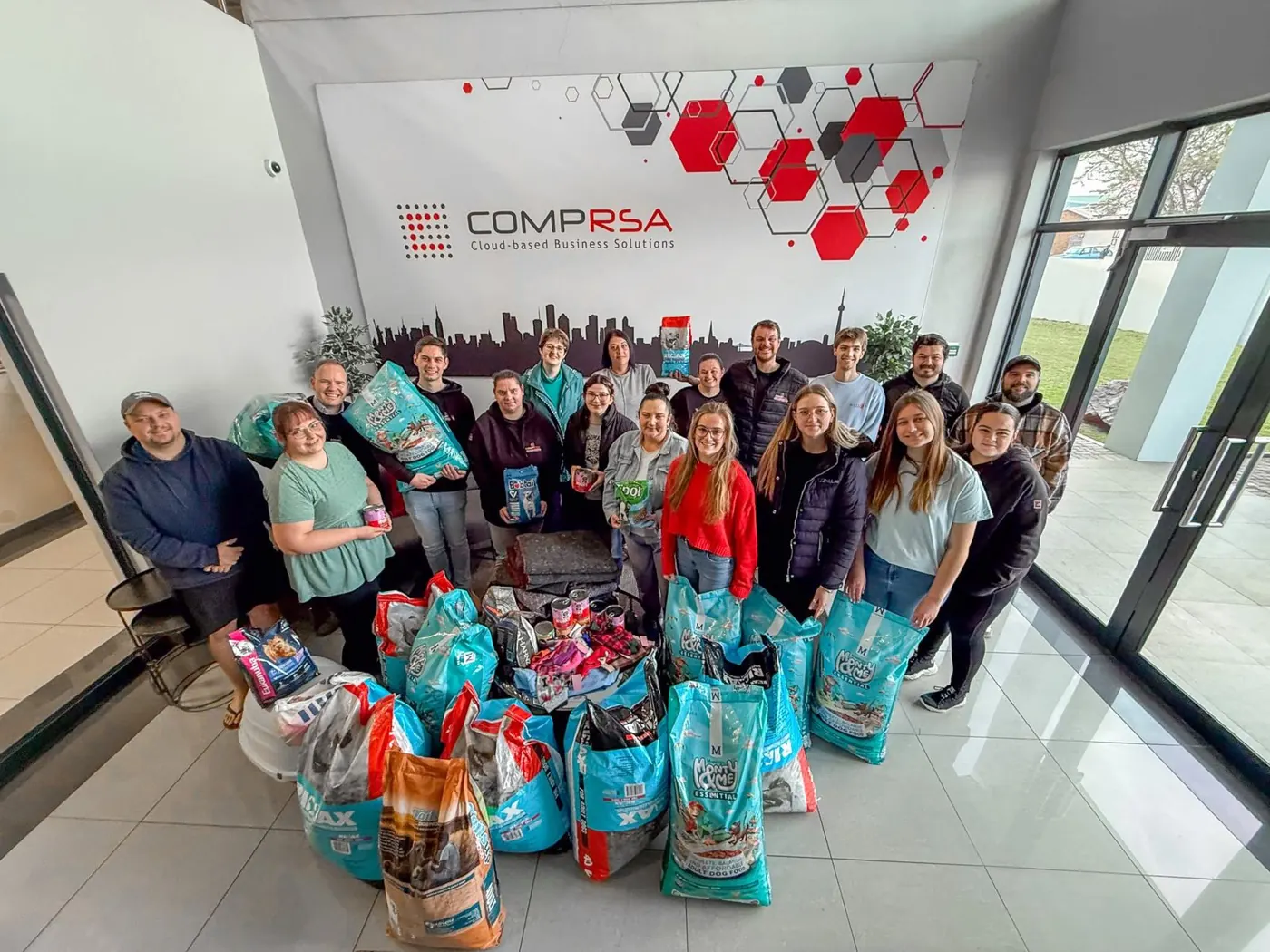 COMPRSA team with pet food donations for local shelters